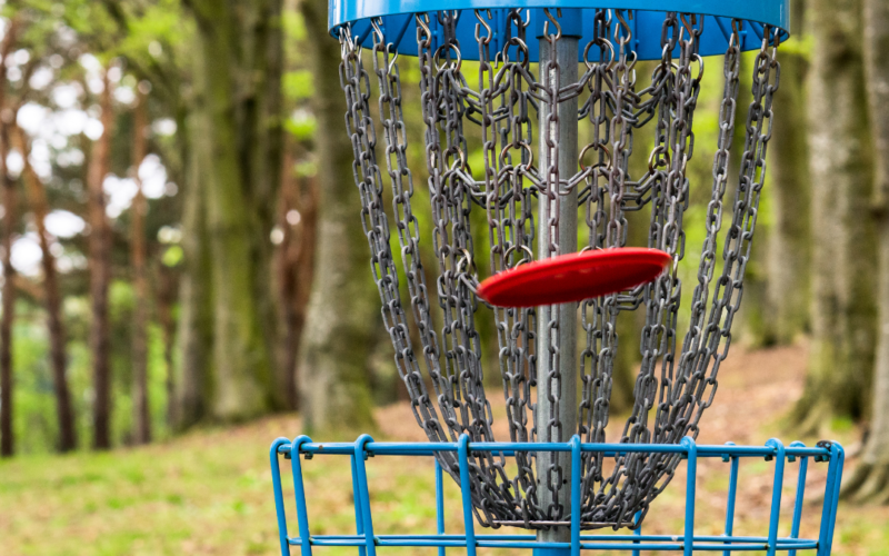 Disc Golf Basket with frisbee in flight