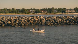 Kayak in front of oyster reef looking to shore.